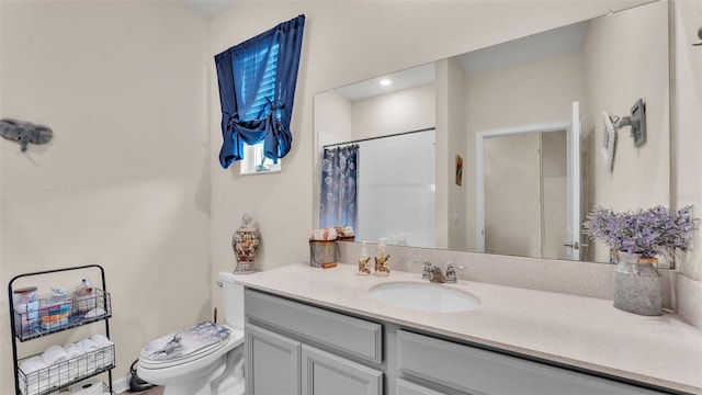 bathroom featuring a shower with shower curtain, vanity, and toilet