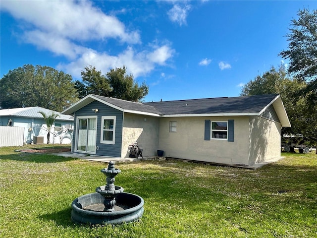 back of house with a lawn and cooling unit