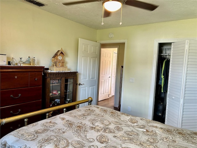 bedroom with a textured ceiling, a closet, and ceiling fan