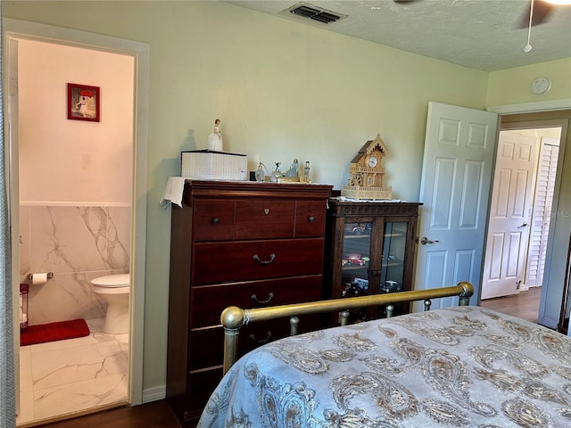 bedroom with dark hardwood / wood-style floors and connected bathroom