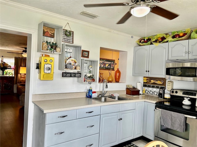 kitchen with appliances with stainless steel finishes, a textured ceiling, ornamental molding, and sink