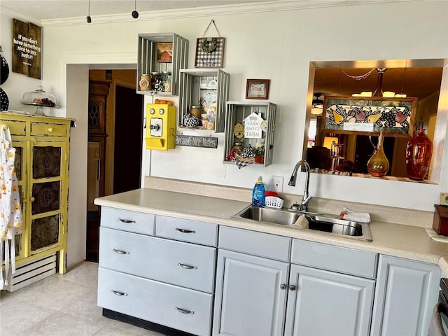 bar with gray cabinetry, pendant lighting, sink, ornamental molding, and light tile patterned flooring