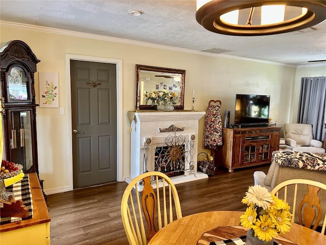 dining space featuring dark hardwood / wood-style flooring, a textured ceiling, and ornamental molding