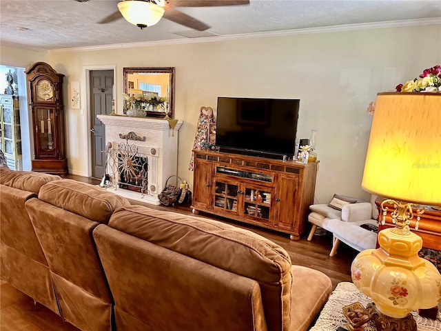 living room with crown molding, ceiling fan, a textured ceiling, and hardwood / wood-style flooring