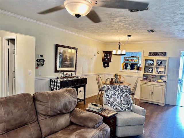 living room with ceiling fan, crown molding, and dark wood-type flooring