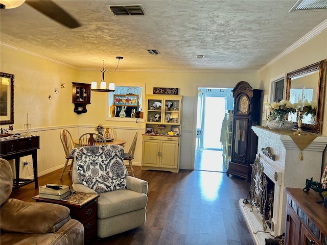 living room with dark hardwood / wood-style floors, ornamental molding, a textured ceiling, and a chandelier