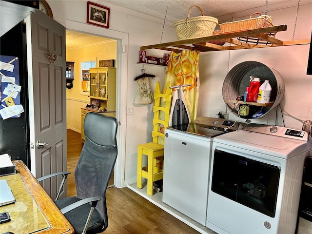 laundry area with washing machine and dryer, crown molding, and dark wood-type flooring