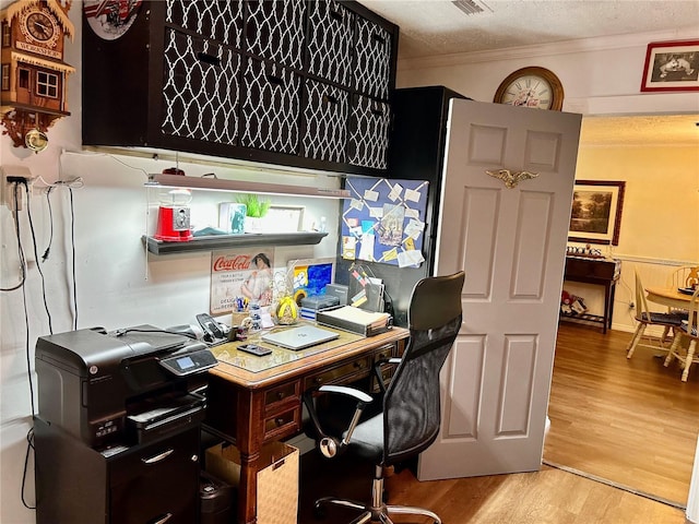 office space featuring a textured ceiling, light hardwood / wood-style floors, and crown molding