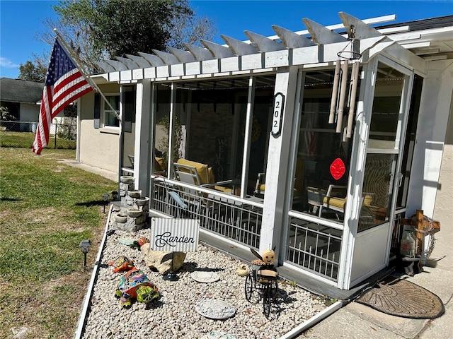 view of property exterior with a pergola, a sunroom, and fence