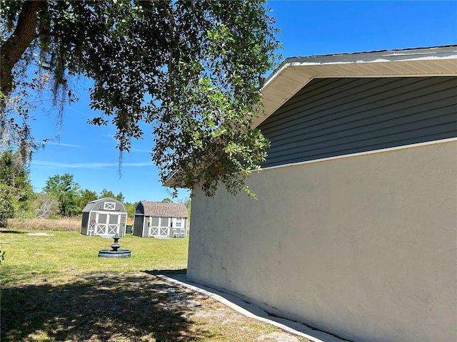 view of home's exterior featuring a storage unit, a lawn, and an outbuilding