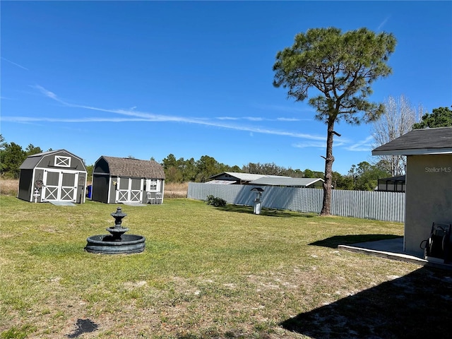 view of yard with an outdoor structure, fence, and a storage shed