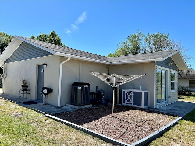 exterior space with central AC unit and stucco siding