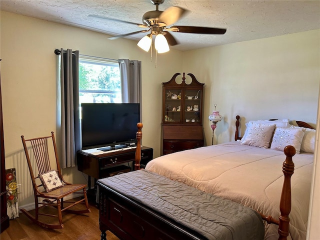 bedroom featuring a ceiling fan, a textured ceiling, and wood finished floors