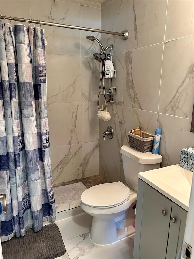 full bath with vanity, marble finish floor, toilet, and tiled shower