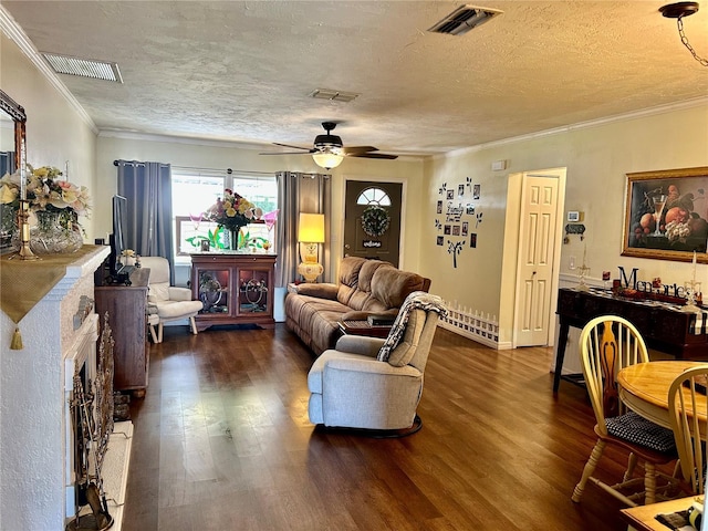 living area with dark wood finished floors, crown molding, ceiling fan, and visible vents