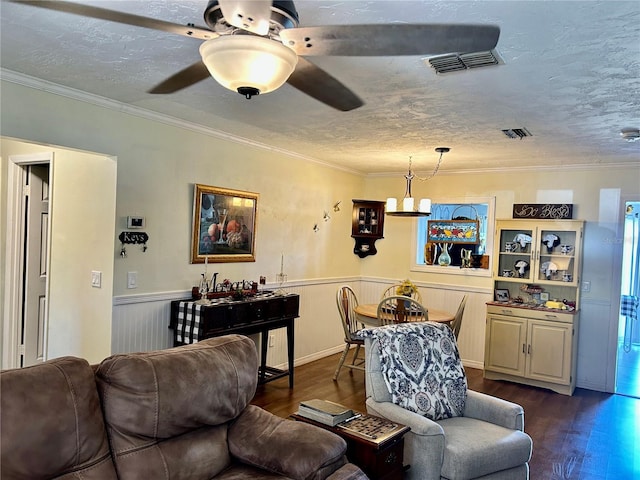 living area featuring a wainscoted wall, dark wood-style floors, and visible vents