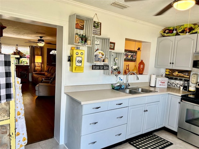 kitchen with visible vents, ceiling fan, ornamental molding, appliances with stainless steel finishes, and a sink