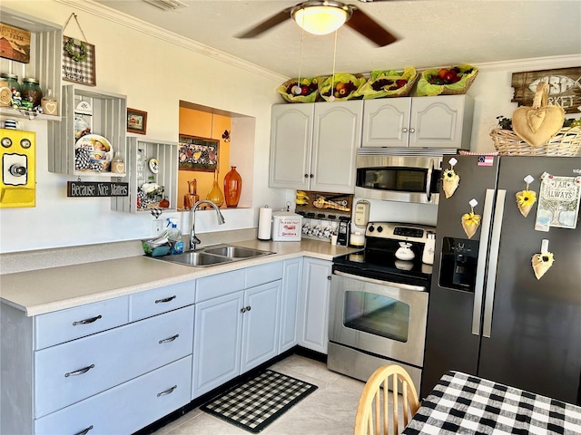 kitchen featuring light countertops, crown molding, stainless steel appliances, a sink, and ceiling fan