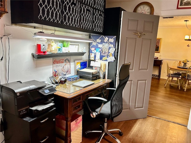 office space with visible vents, light wood-style flooring, and crown molding