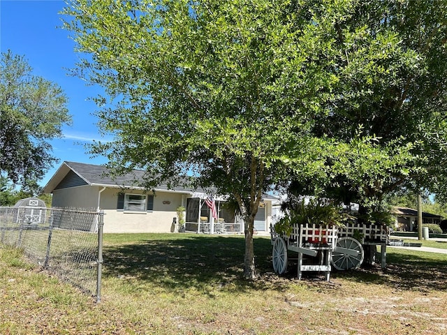 view of front of house featuring a front yard, stucco siding, and fence