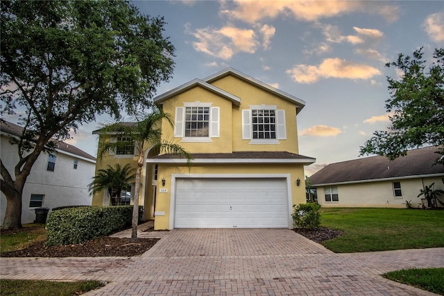 view of front of home with a garage and a lawn