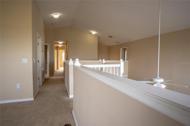 hallway featuring light colored carpet and vaulted ceiling