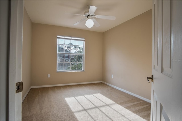 empty room with ceiling fan and light carpet