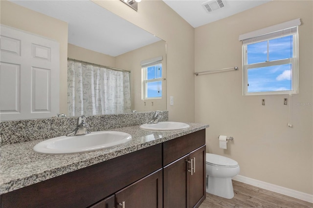 bathroom with hardwood / wood-style floors, vanity, and toilet