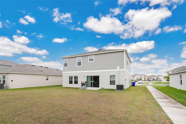 rear view of property with a lawn and cooling unit