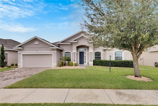 332 Lake Mariana Way, Auburndale, FL 33823 - view of front of house with a garage, decorative driveway, a front lawn, and stucco siding