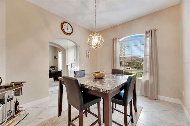 tiled dining room featuring a chandelier