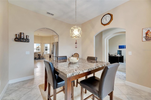 tiled dining room featuring a notable chandelier