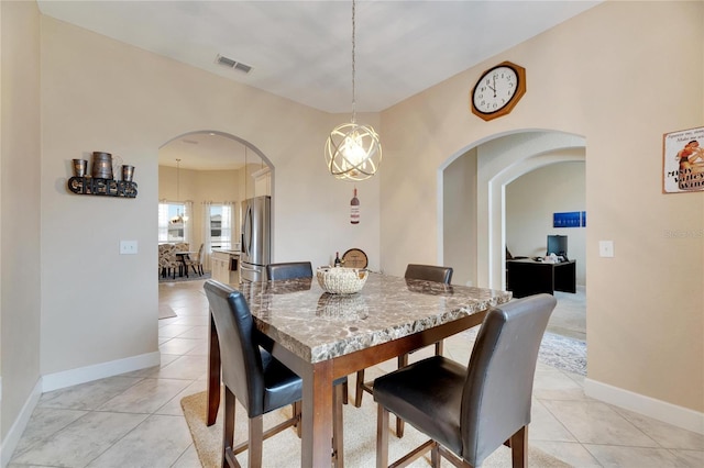 332 Lake Mariana Way, Auburndale, FL 33823 - dining room with light tile patterned flooring, arched walkways, and a chandelier