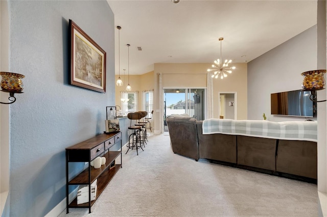 carpeted living room featuring an inviting chandelier