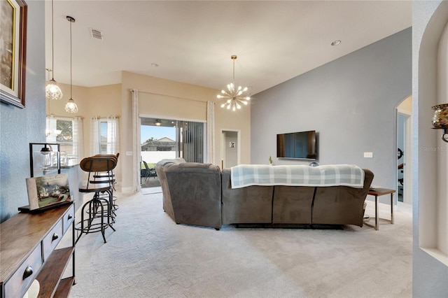 living room with light carpet, a high ceiling, and an inviting chandelier