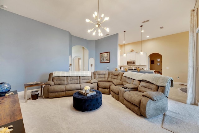 332 Lake Mariana Way, Auburndale, FL 33823 - carpeted living room featuring arched walkways, a chandelier, and a high ceiling