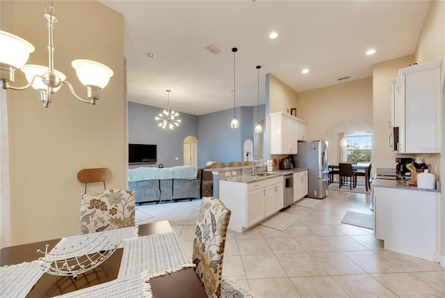 332 Lake Mariana Way, Auburndale, FL 33823 - kitchen with stainless steel appliances, a chandelier, white cabinets, light stone counters, and recessed lighting