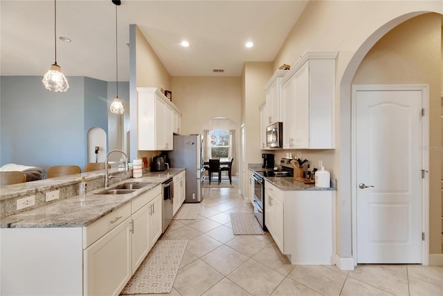 kitchen with white cabinetry, pendant lighting, stainless steel appliances, and sink