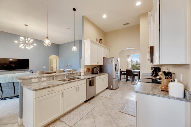 332 Lake Mariana Way, Auburndale, FL 33823 - kitchen with arched walkways, stainless steel appliances, open floor plan, a peninsula, and white cabinets