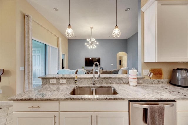 kitchen featuring sink, stainless steel dishwasher, decorative light fixtures, light stone counters, and white cabinetry