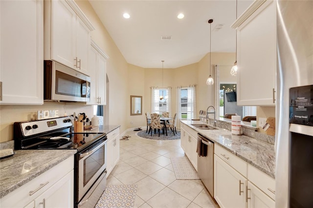 kitchen with sink, light stone countertops, decorative light fixtures, light tile patterned flooring, and stainless steel appliances