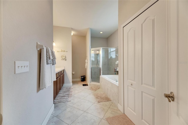 bathroom featuring plus walk in shower, vanity, and tile patterned flooring