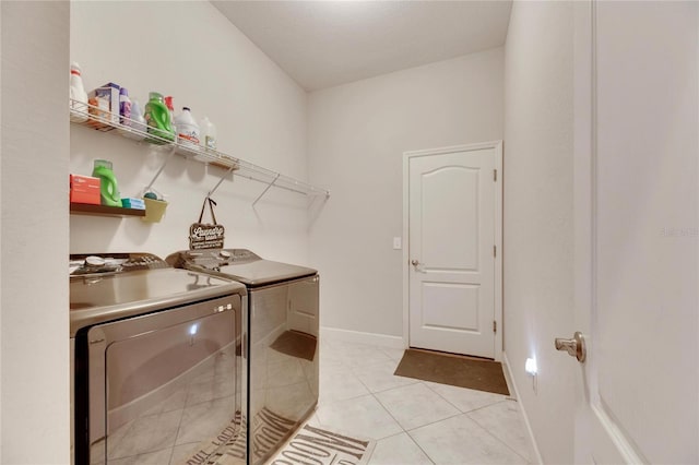 laundry area featuring washer and clothes dryer and light tile patterned floors