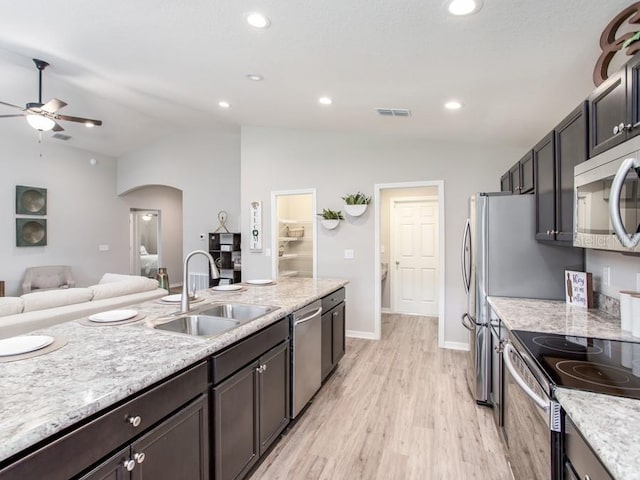 kitchen with light stone countertops, stainless steel appliances, lofted ceiling, and sink