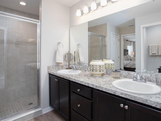 bathroom featuring hardwood / wood-style flooring, vanity, and walk in shower