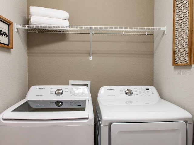 clothes washing area featuring washer and dryer