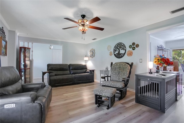 living room with ceiling fan, light wood-type flooring, and ornamental molding