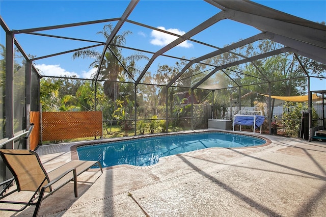 view of pool featuring glass enclosure and a patio area