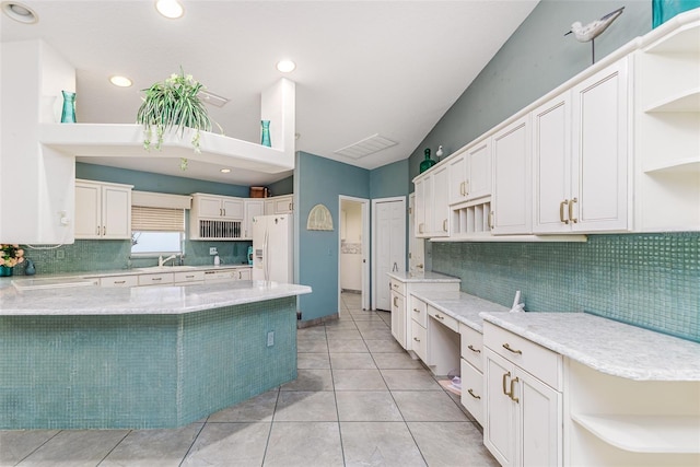 kitchen with backsplash, white fridge with ice dispenser, white cabinets, and light tile patterned flooring