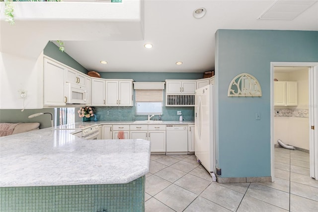 kitchen featuring kitchen peninsula, white appliances, light tile patterned floors, white cabinets, and plenty of natural light